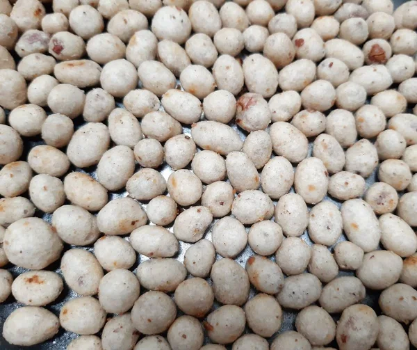 White and brown round nuts and flour snack texture a.k.a. sukro. Indonesian traditional snack made from tapioca flour and nut inside.