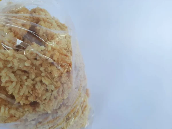 Rengginang, izole edilmiş beyaz arka plana şeffaf plastikle sarılmış. Geleneksel Endonezya atıştırmalıkları bir seyahatten getirilen hediye olarak kullanılır.