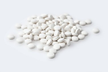 Heap of medicine white pills, antibiotic tablets, drugs. Pharmacy theme