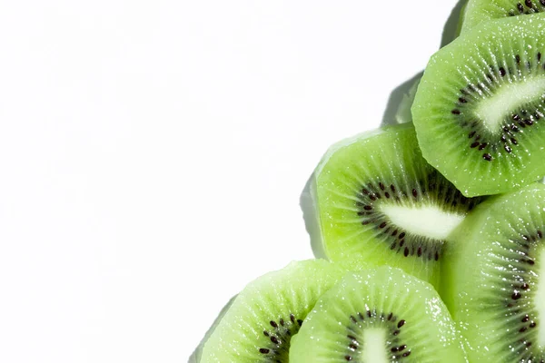 Beyaz arkaplanın köşesinde dilimlenmiş kivi, metin için boşluk