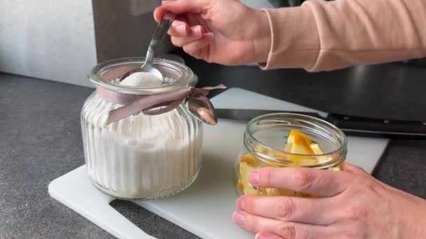 キッチンカウンターのレモンスライスに粒状の砂糖を注ぐ女性の手 高品質の4K映像 遅いズームイン — ストック動画