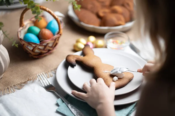 Paskalya 'da çocuk dekore eden tavşan şekilli zencefilli kurabiye kurabiyelerinin elleri. Tatil gelenekleri, aile zamanı.