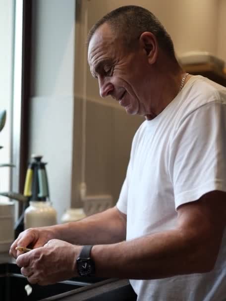 Hombre Jubilado Pelando Patatas Con Pelador Verduras Cocinar Casa Comida — Vídeos de Stock