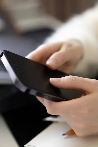 Ofiste ya da evde akıllı telefon kullanan tanınmayan bir kadının yakın çekimleri. Çevrimiçi alışveriş kavramı, sosyal medya sörfü, dijital aygıt kullanarak kablosuz iletişim