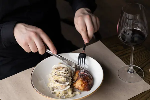 Masa bıçağı ve çatal kullanan erkek eller kızarmış tavuk, hindi, kremalı makarna ya da patates püresi ile yemek kesiyorlar. Masada bir kadeh kırmızı şarap, karanlık bir ruh hali.