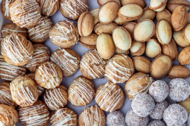 Çeşit çeşit tatlı tatlılar. Bir çift tatlı yumuşak kek. Muhallebi kekleri, yoğunlaştırılmış sütlü fındıklar, hindistan cevizli tatlı toplar. Yukarıdan bak. Üst görünüm