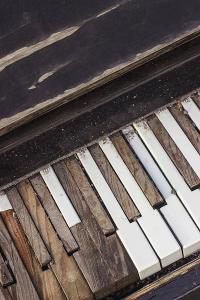 Old broken piano. Keyboard with broken, peeled piano keys.