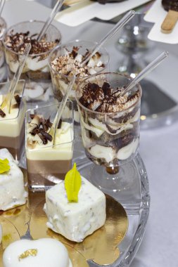 Düğün çikolatası. Tatlı meyveli tatlılarla dolu bir masa. Beyaz çikolatalı kalpler, çilekli tatlılar, fıstıklı pasta, tiramisu, çikolatalı dondurma. Düğün, parti, doğum günü için güzel bir masa. 