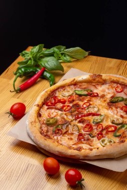 Jalapeno pizzası iştah açıcı. Ahşap bir masada baharatlı pizza. İtalyan mutfağı. Pizza tarifi. Pizza yapma süreci. Diablo.