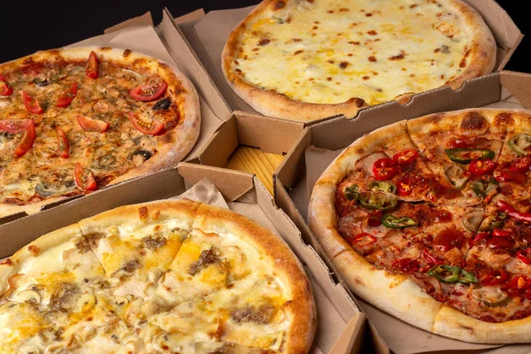 Ahşap bir masada farklı pişmiş pizzalar. Restoran menüsü, pizza. Çeşitli pizza çeşitleri..