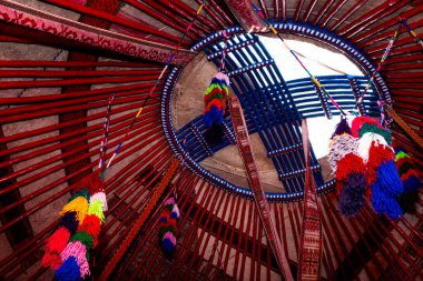 İçerideki geleneksel Kazak yurdunun üst kısmı renkli püsküllerle süslenmiş. Göçebeler Evi.