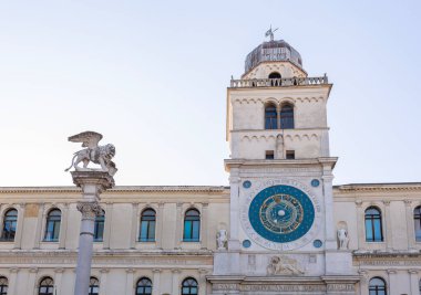 Astronomik saat kulesi, Torre dellOrologio Piazza dei Signori, Padua, İtalya 'dan görüldü. Ön planda Venedik aslanının heykeli var.