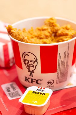Padova, İtalya - 15 Nisan 2025 KFC Kentucky Fried Chicken olarak bilinen popüler bir fast food zinciri. Bir sürü tavuk kanadı ya da kovada KFC tavuğu, Padova, İtalya 'da fast food' da mayonez sosu.. 