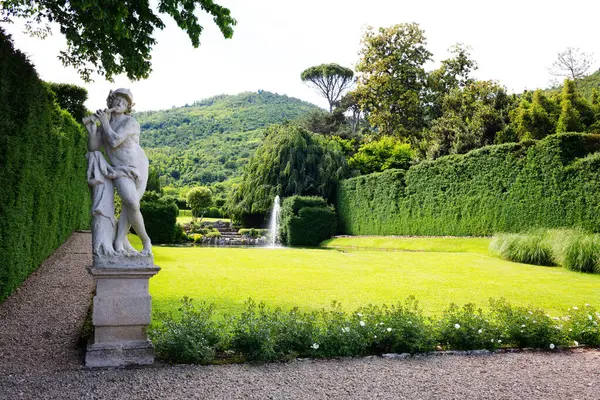 Merkür 'ün flüt çalan heykeli Valsanzibio' nun huzur ve sükunet yeri olduğunu sembolize eder. Villa Barbarigo Valsanzibio Padua Galzignano Terme.