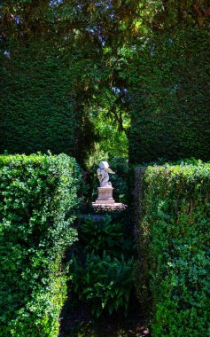 Monumento al Tempo, Zaman Anıtı, Villa Barbarigo Valsanzibio Padua Galzignano Terme 'deki güneş ışınlarında bulunan lüks ağaçların yapraklarıyla çevrilidir.