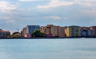 İtalya 'da akşam güneşinde sakin bir laguna Chioggia manzarası. Uzakta büyüleyici binalar sergileniyor. Seyahat ilhamı için ideal.
