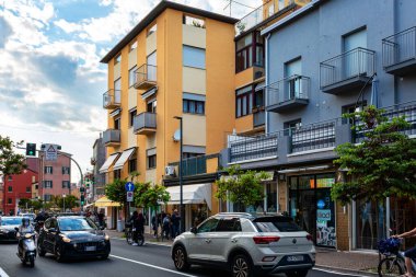 Sottomarina, İtalya - 25 Mayıs 2025: Şehir sokak manzarası modern mimari, araçlar ve yayaların canlı şehir hayatı ve toplum etkileşiminin özünü yansıtıyor