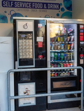 Sottomarina, İtalya - 25 Mayıs 2025: Bir self-servis gıda alanında yiyecek ve içeceklerle dolu otomat, kullanıcılar için kolaylık ve çeşitliliği vurguluyor