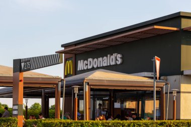 Monselice, İtalya - 28 Mayıs 2025: McDonald 's restoranında açık hava oturma alanı, sembolik markalaşma ve müşterilerin yemeklerini yemesi için canlı bir atmosfer bulunmaktadır.