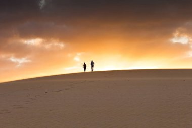 Kumsalda sırt çantalı bir adam.