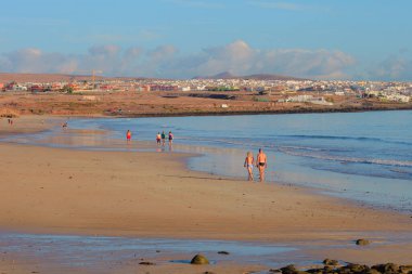 Denizin arka planında bir dalga olan güzel bir plaj görüntüsü.