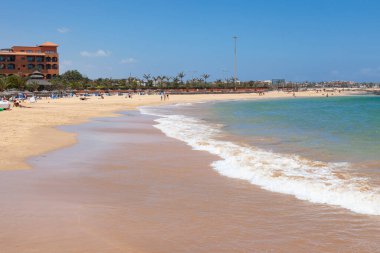 Deniz dalgaları ve mavi gökyüzü olan güzel sahil