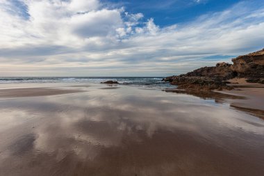 Deniz dalgaları ve mavi gökyüzü olan güzel sahil