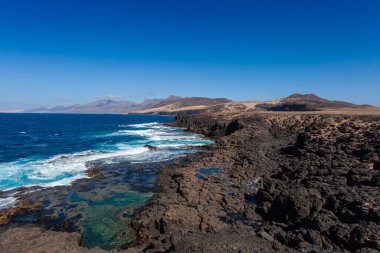 Fuerteventura adasının güney batısındaki kayalık yamaçların güzel plajı.