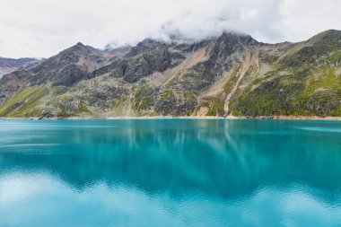 Avusturya Alp Dağları 'ndaki Finstertaler rezervuarı. Etrafı mavi sular ve güzel dağlarla çevrili.