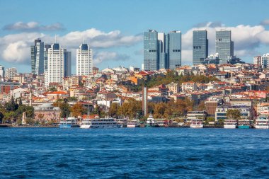 Istanbul, Turkey - October 9th, 2019: View to the shore of Bosforus strait on an early autumn day. Residential buildings and skyscrapers along the shore.