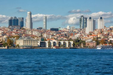 View to the shore of Bosforus strait on an early autumn day. Residential buildings and skyscrapers along the shore.