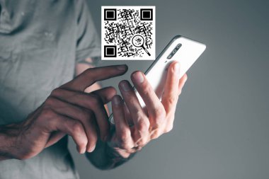 Adam telefondaki QR koduna tıklıyor.