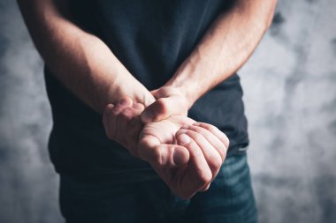 Adamın elinde bir ağrı var.