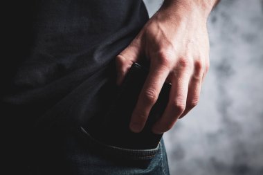 man puts her wallet in her pocket