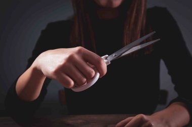 Genç bir kadın büyük bir makas tutuyor.