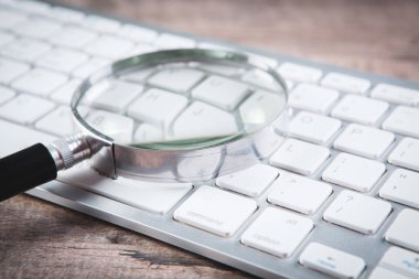 İnternet arama kavramı, büyüteç ve bilgisayar klavyesi