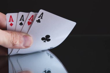 Kağıt oynayan dört aslı poker eli.