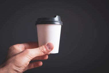 Gri arka planda tek kullanımlık kahve bardağı.