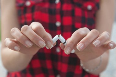 Genç kız sigarasını kırıyor.