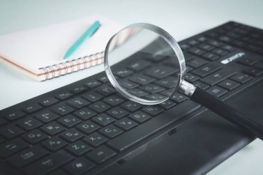 İnternet arama kavramı, büyüteç ve bilgisayar klavyesi