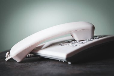 Masadaki beyaz ev telefonu.