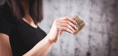 Elinde büyük para tutan bir kız.