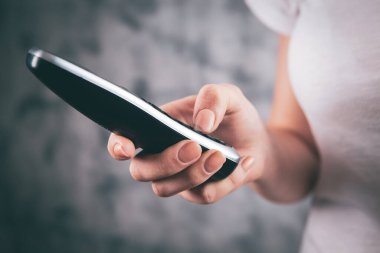 Elinde telefon tutan genç bir kız.