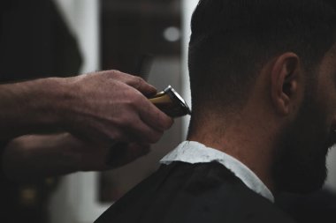 Erkek müşteri kuaföre tıraş oluyor.