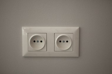Evde iki beyaz elektrik prizi var.