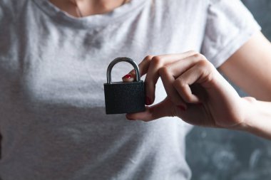 Kadın asma kilit tutuyor.