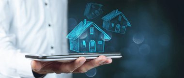 ev kavramı arka planda bir tablet tutan ellerin üzerinde