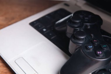 Bir klavyenin yakın çekim görüntüsü ve bulanık arkaplanda beyaz bir joystick.