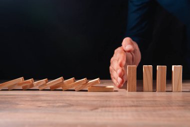 Tahta bir masanın üzerinde tahta küpleri olan bir iş adamı.