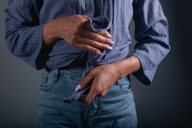 Cebinde mavi gömlekli bir adam elinde bir cüzdan tutuyor..